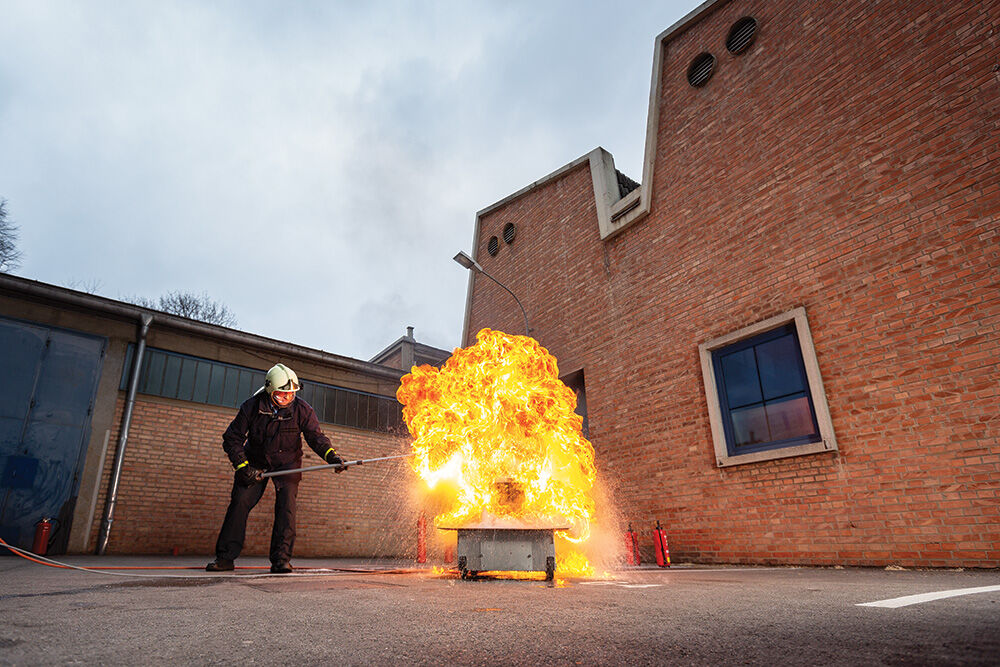 Mann, der ein Feuer in einem Kurs löscht